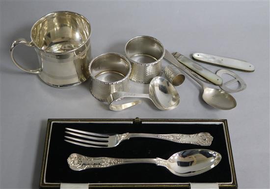 A cased George V silver Christening pair and other silver items including napkin rings, Christening mug and fruit knives.